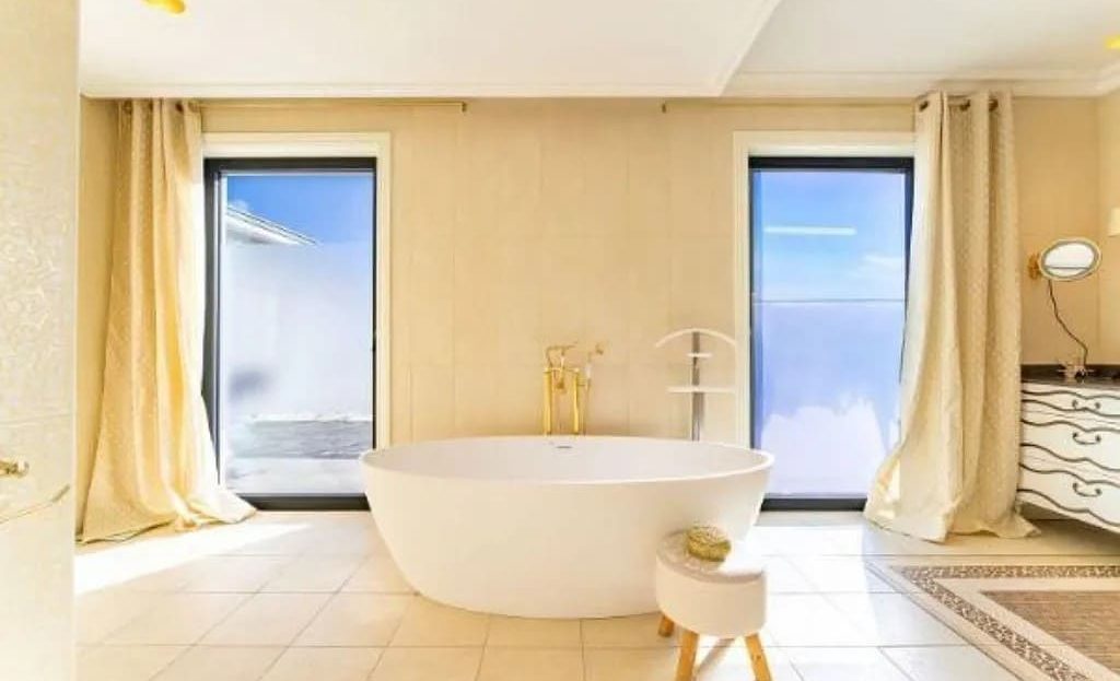 Ванная комната с отдельно стоящей ванной и большим окном
