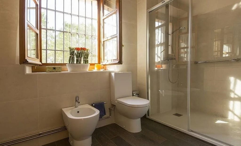 Ванная комната с окном и отделкой из натурального камня