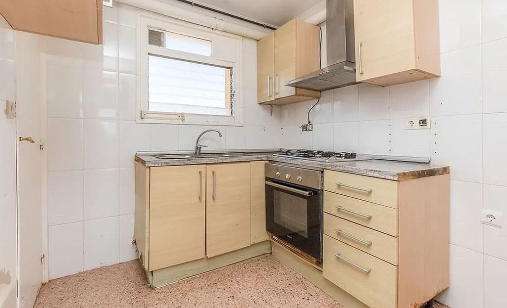 Кухня квартиры с плитой, шкафами и рабочей зоной