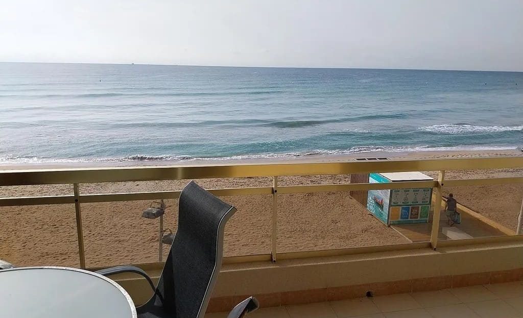 Терраса квартиры с видом на море и столиком для отдыха.