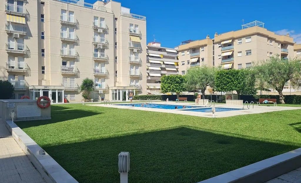 Общая территория жилого комплекса с зелёной зоной и бассейном.