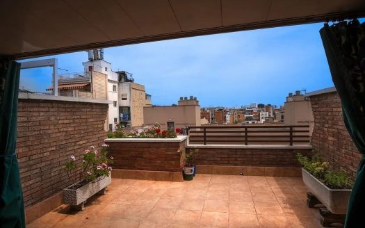 Просторная терраса пентхауса с зоной отдыха и видом на крыши домов