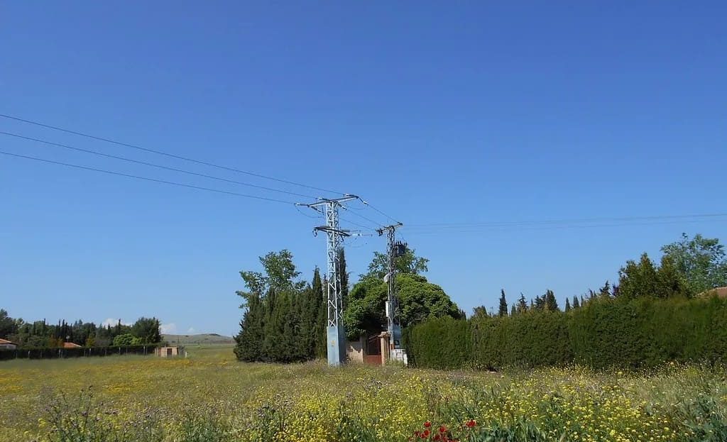 Участок земли в Реус — вид на поле с линиями электропередач и зелёными насаждениями