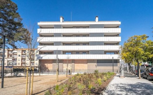 Современный фасад многоквартирного дома с зелёной зоной перед зданием