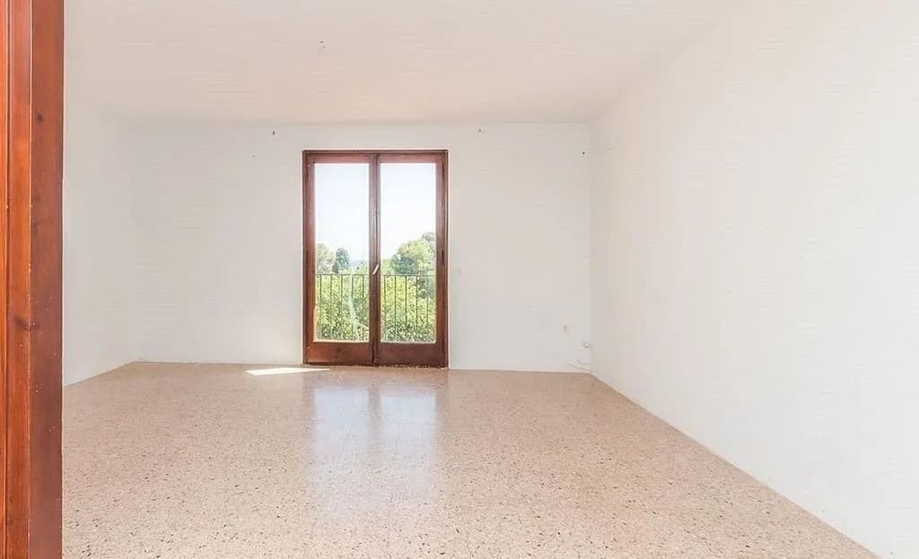 Светлая пустая спальня с окном и плиточным полом