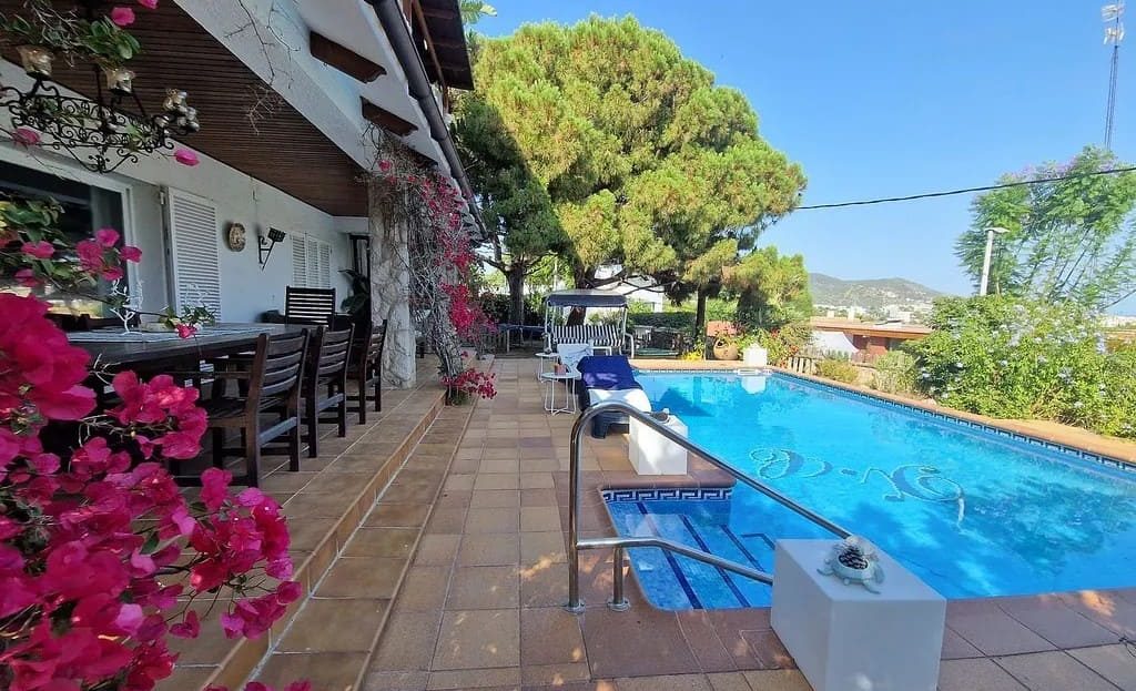 Частный бассейн и зона отдыха на участке виллы в Ситжесе