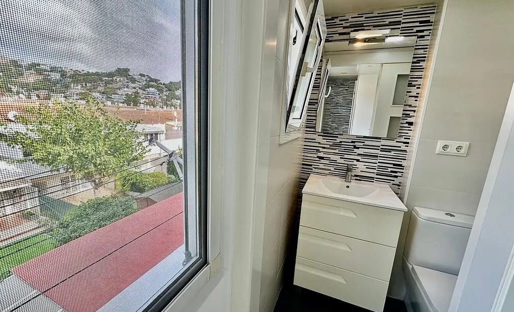 Ванная комната с окном и современной отделкой.