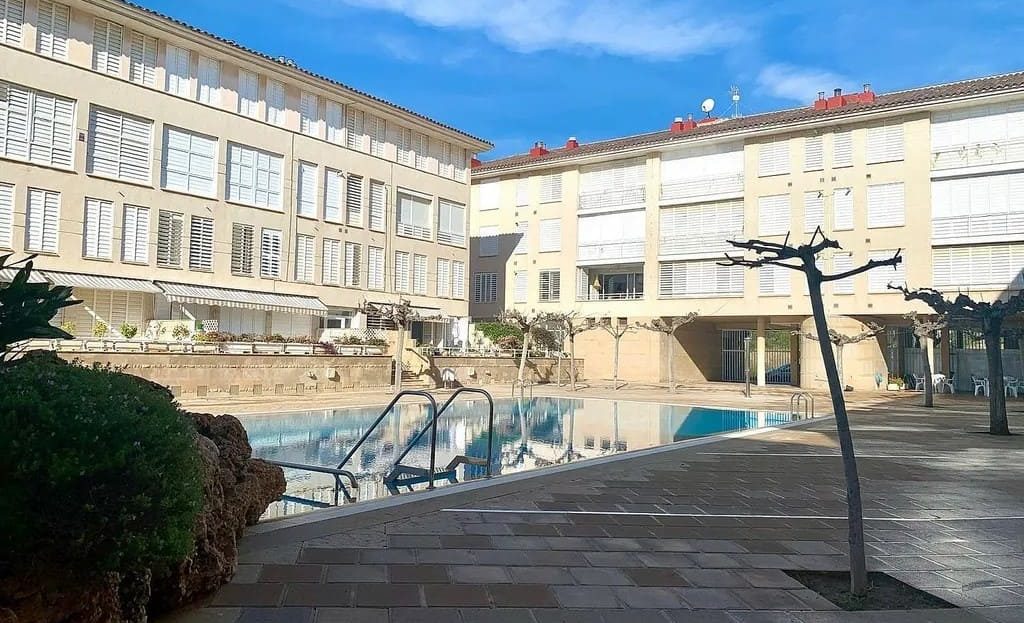 Территория бассейна, здание комплекса и зоны отдыха вокруг.