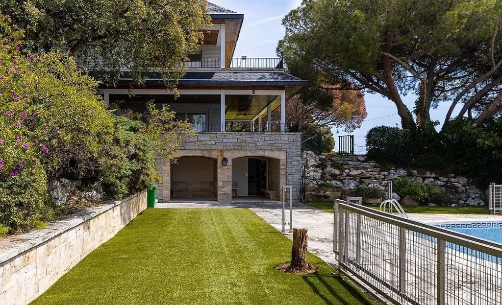 Сад и газон перед домом с выходом к зоне бассейна.