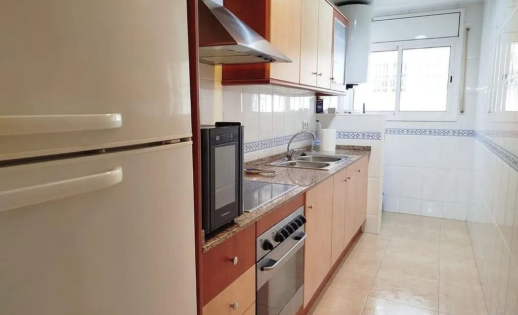 Отдельная кухня с бытовой техникой и большим окном.