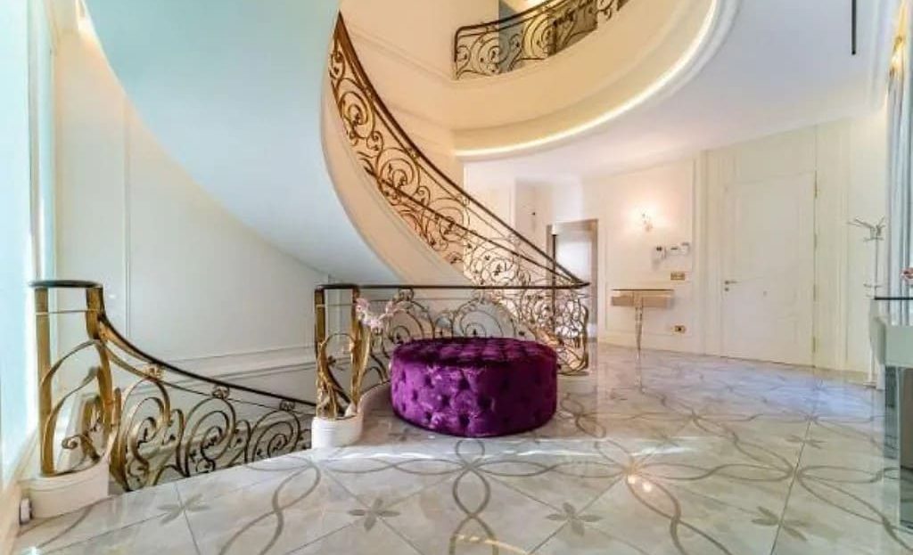 Парадная лестница с дизайнерскими перилами в холле