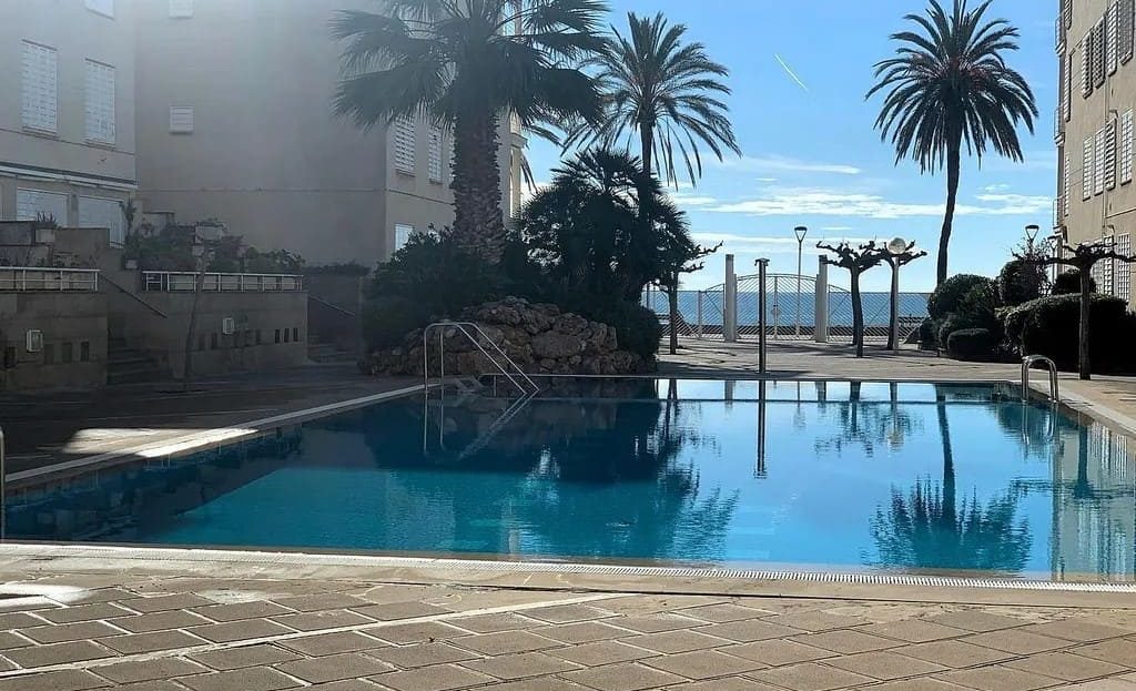 Бассейн с морем на горизонте и пальмами по периметру.