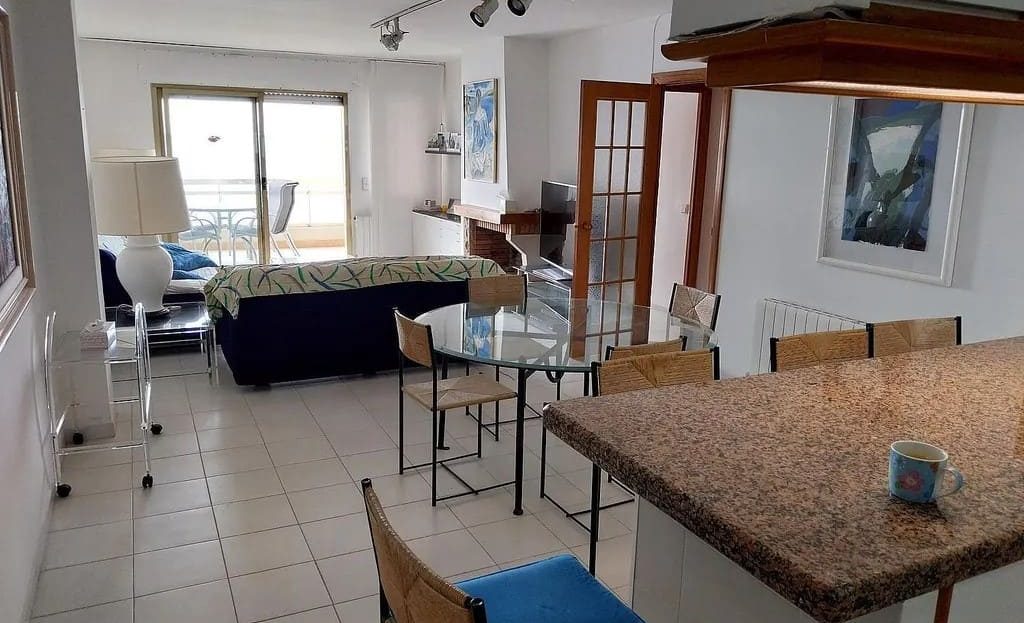 Гостиная с зоной отдыха и столовой, выходящей на террасу с видом на море.