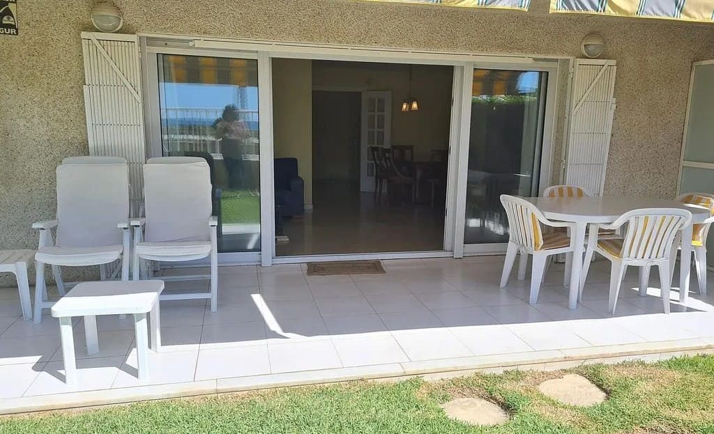 Терраса с мебелью и видом на сад и набережную.