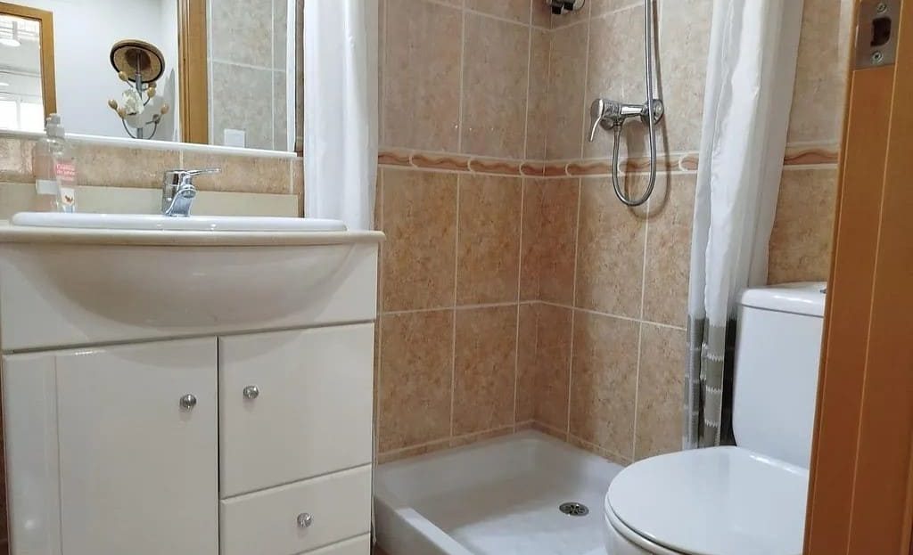 Ванная комната с душевой, раковиной и туалетом.