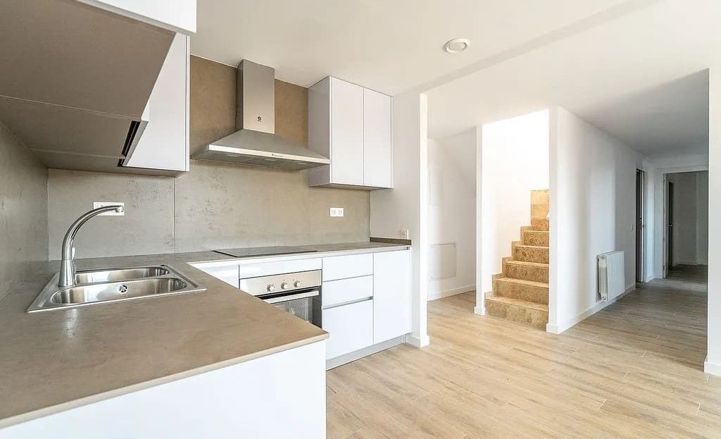 Современная кухня с встроенной техникой и обеденной зоной