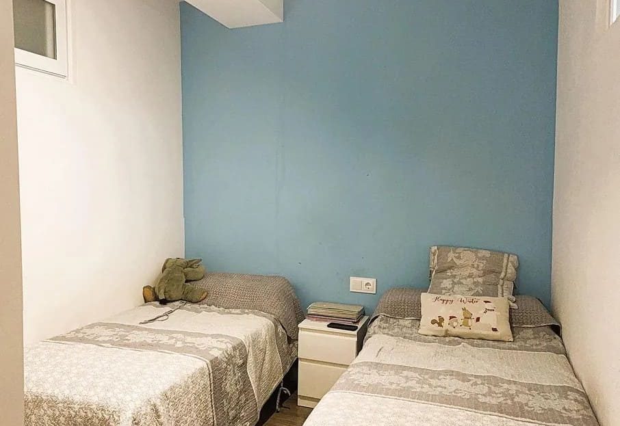 Спальня с двумя односпальными кроватями и естественным освещением