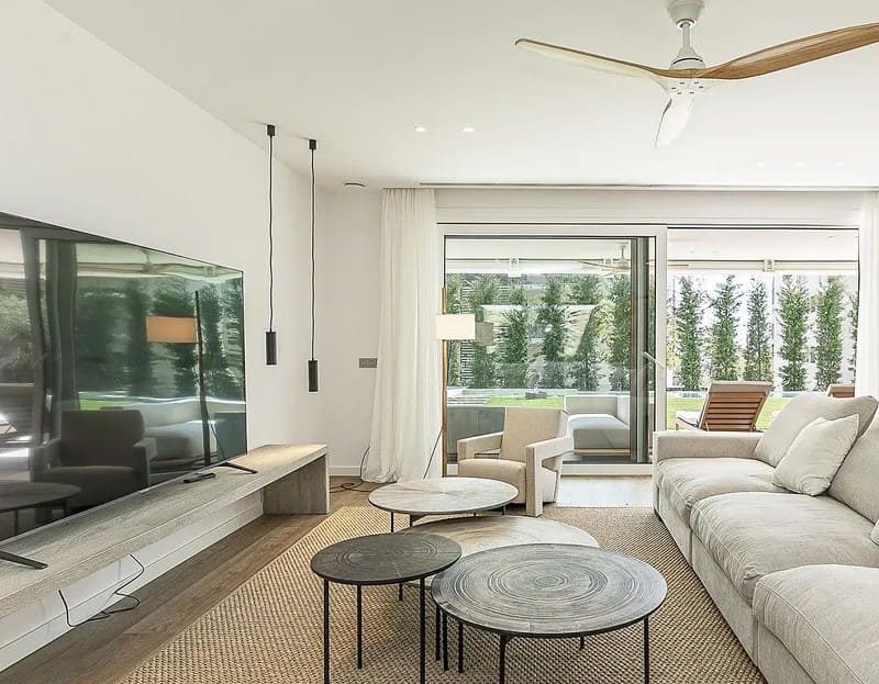 Светлая гостиная с современной мебелью и видом на зелёную зону