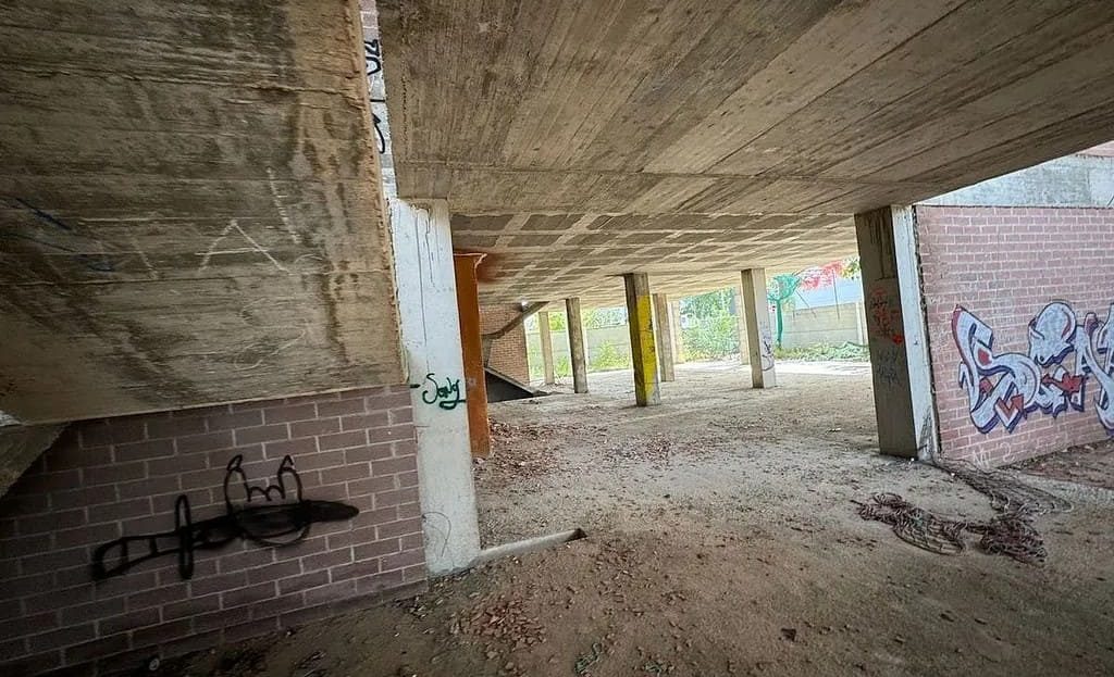 Бетонные конструкции и колонны в зоне первого этажа, видны незавершённые стены.