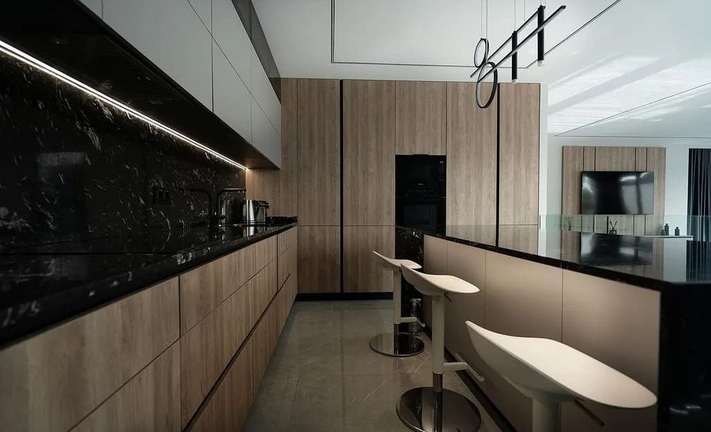 Дизайнерская кухня с барной стойкой и современной отделкой.