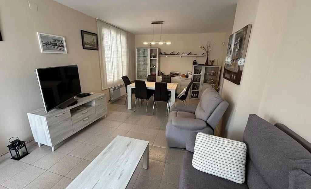 Гостиная с мебелью, телевизором и столовой зоной.