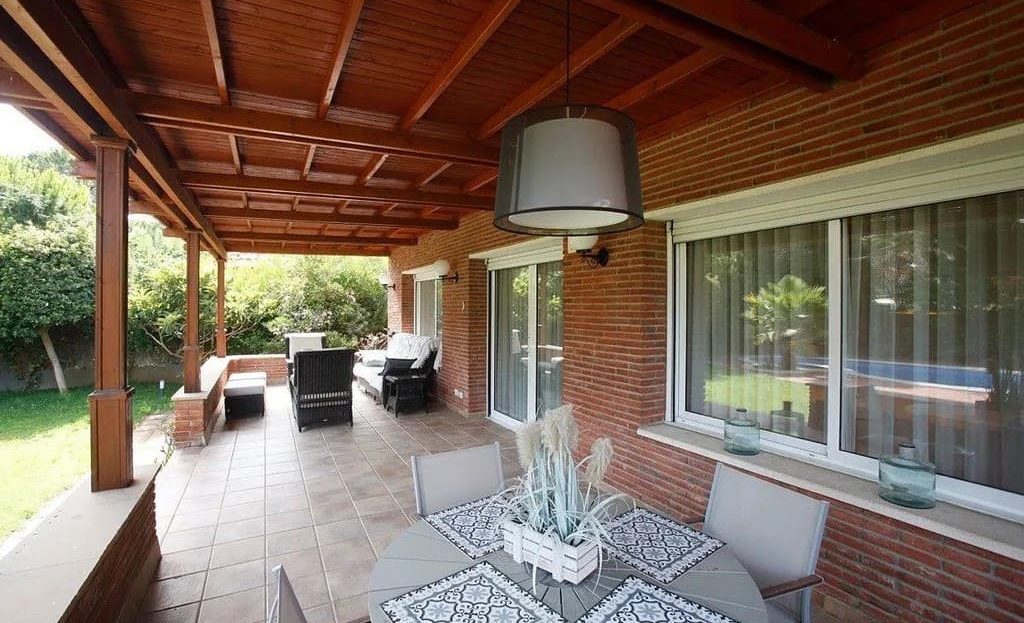 Крытая терраса с зоной отдыха и выходом в сад.