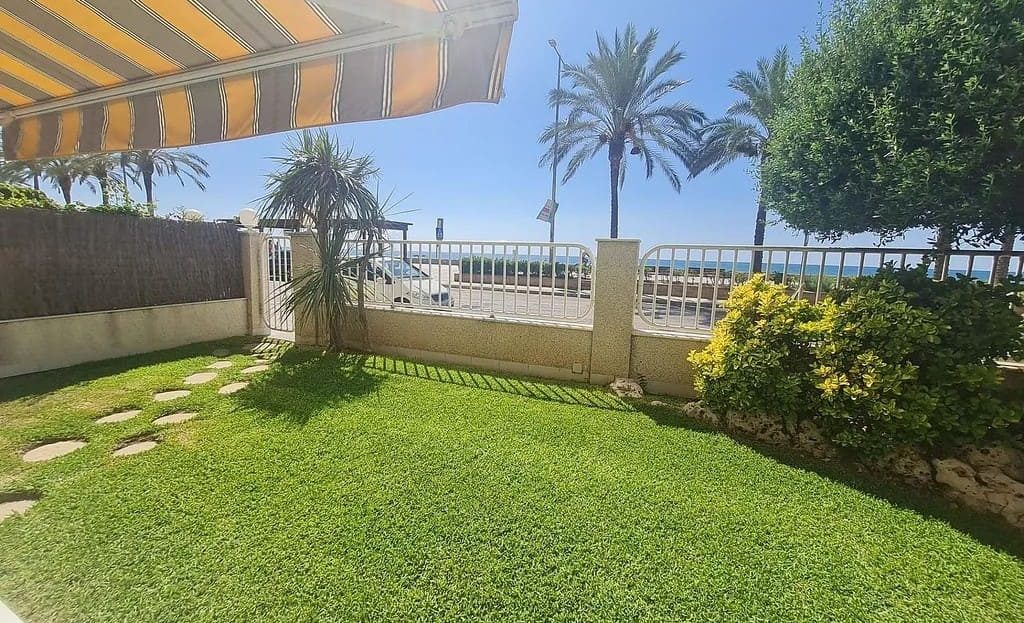 Частный сад с видом на пляж и пальмы.