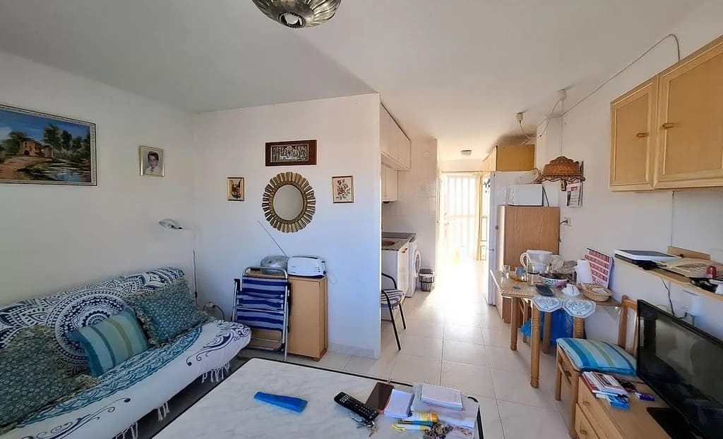 Гостиная-студия с диваном, обеденной зоной и выходом на балкон.