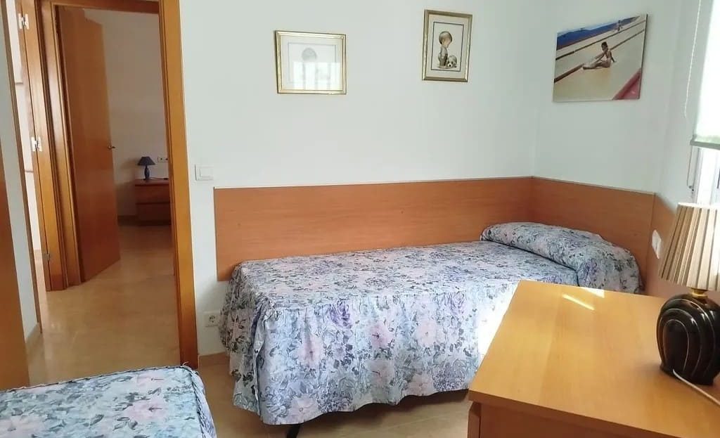 Спальня с двумя односпальными кроватями и окном.