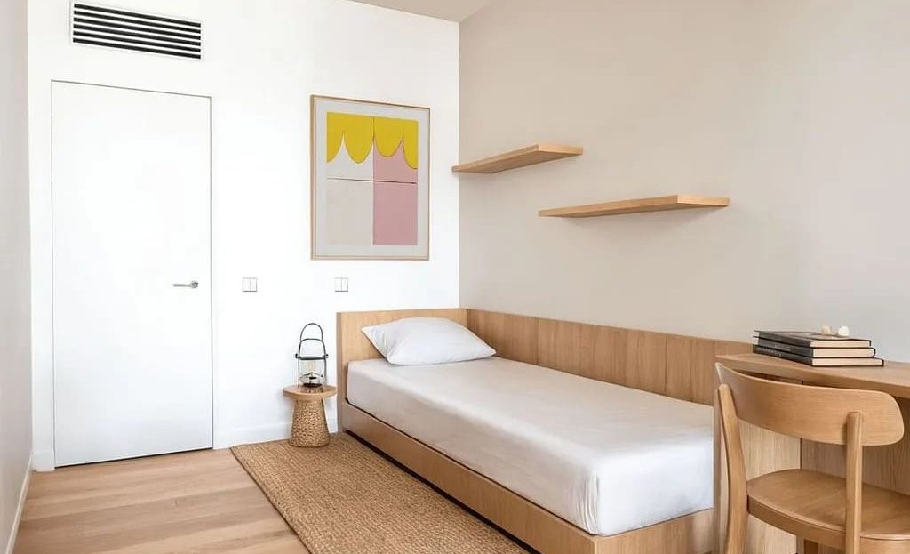 Одноместная спальня с деревянной отделкой и рабочим столом, современный дизайн