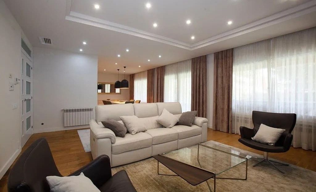 Просторная гостиная с мягкой мебелью и естественным освещением.