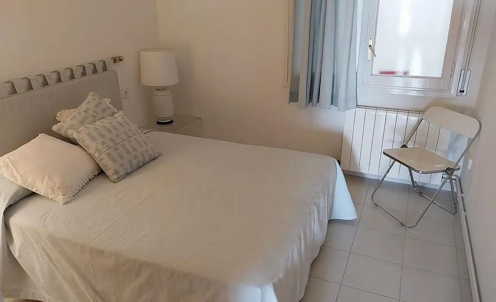 Основная спальня с двуспальной кроватью и светлым интерьером.