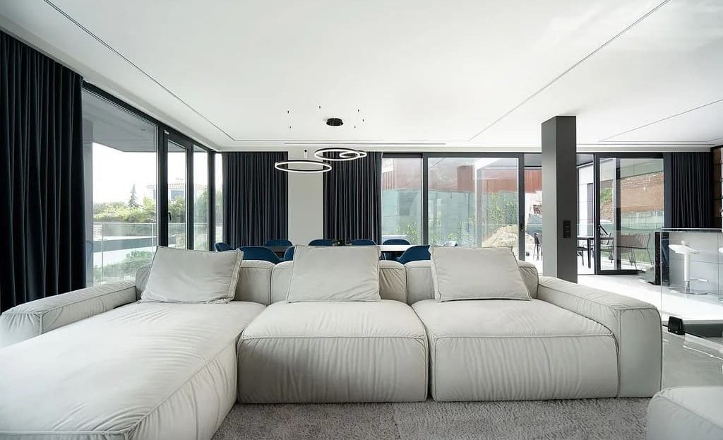 Просторная гостиная с панорамным остеклением и выходом на террасу.