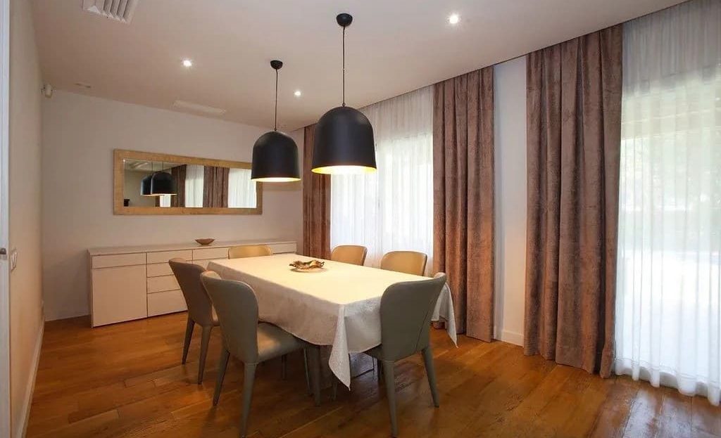 Столовая зона с выходом к окнам и современным освещением.