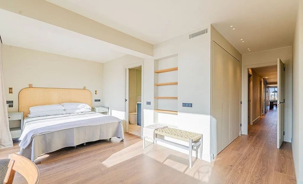 Спальня пентхауса с естественным освещением и деревянным полом