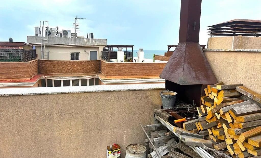 Барбекю-зона на террасе с дровами и оборудованием.