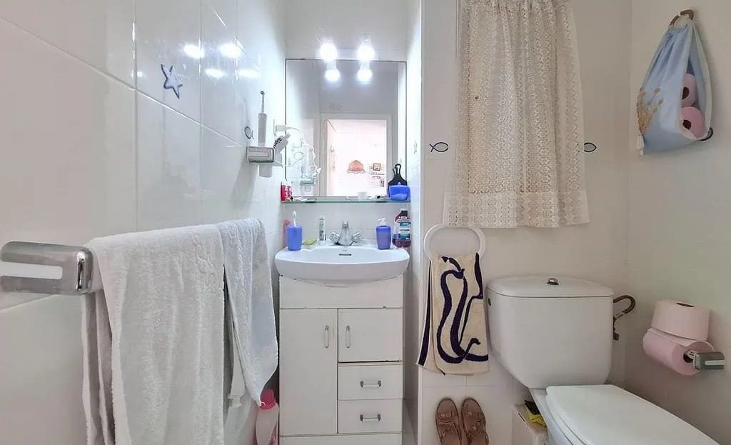 Ванная комната с раковиной, зеркалом и туалетом.