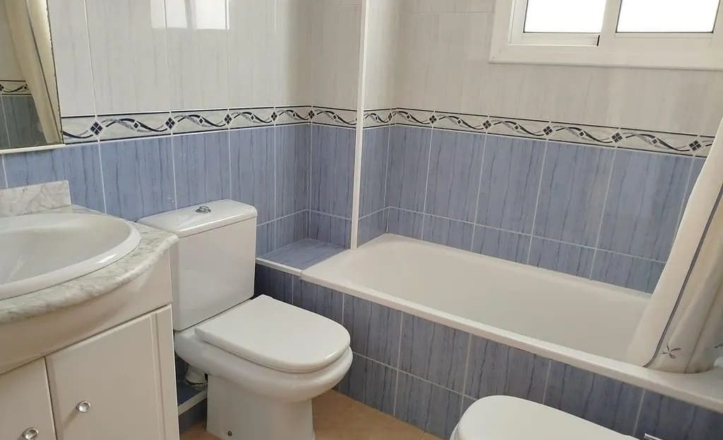 Ванная комната с ванной, раковиной, туалетом и окном.