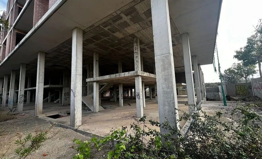 Пространство под зданием с бетонными колоннами и открытыми техническими зонами.