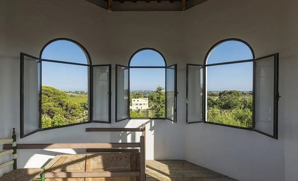 Круглая комната с панорамными окнами и видом на сады