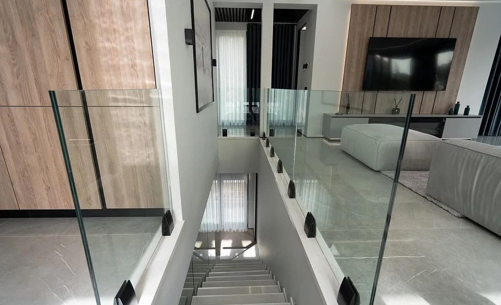 Внутренний холл с галереей и стеклянными перилами.