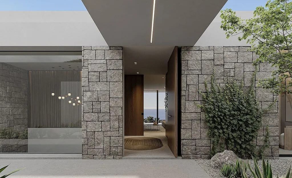 Вход в дом с каменными колоннами и современным дизайном.