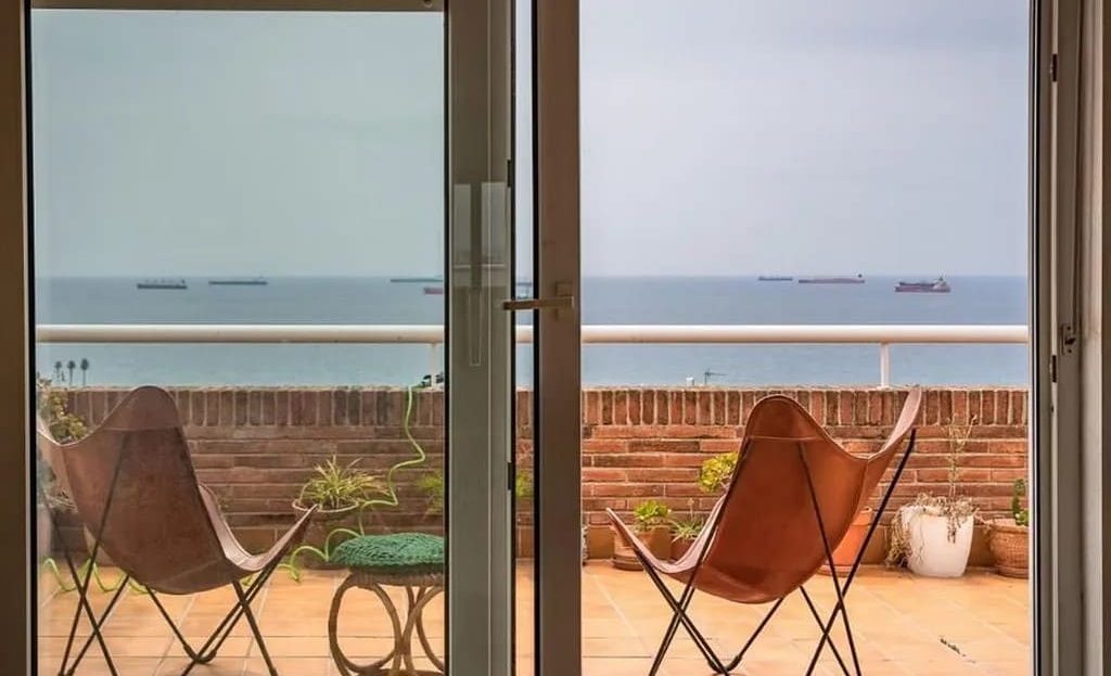 Панорамная терраса таунхауса в Таррагоне с видом на море и зоной для отдыха.