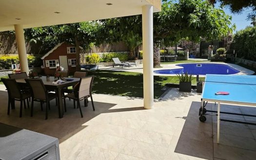 Терраса дома в Испании с обеденной зоной, видом на сад и частный бассейн.