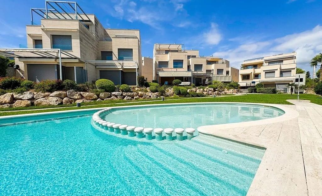 Вид на жилой комплекс с общим бассейном и садом в доме в Испании на первой линии моря.