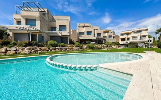 Вид на жилой комплекс с общим бассейном и садом в доме в Испании на первой линии моря.