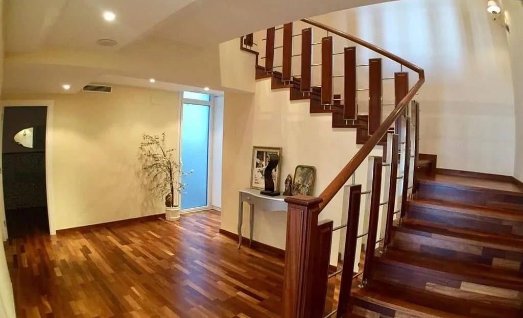 Дизайнерская лестница из натурального дерева, соединяющая уровни виллы.