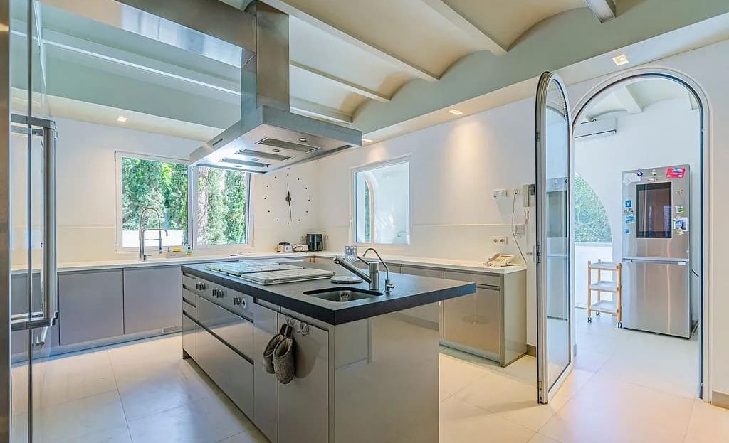 Вид на кухню и обеденную зону со стороны холла. Просторное помещение с высокими потолками.