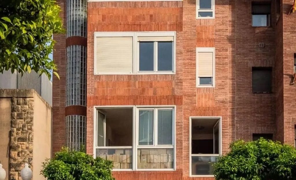 Кирпичный фасад таунхауса в Таррагоне с балконами и террасами.