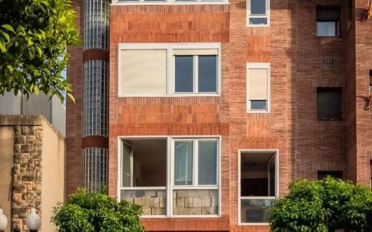 Кирпичный фасад таунхауса в Таррагоне с балконами и террасами.